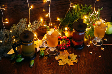 Autumn tea in french press and citrus tea in transparent mug with apple, feijoa and lychee on the table in restaurant