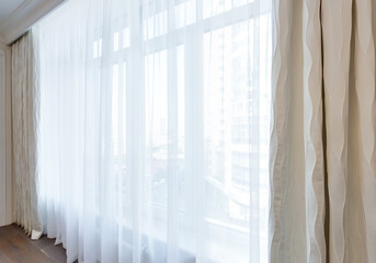 Large window in the room with tulle and curtains. Modern interior