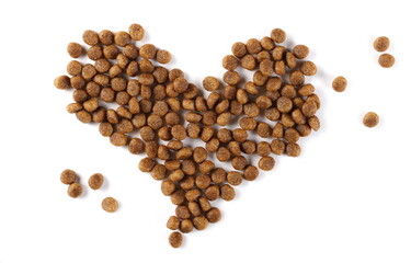 Dog food, dry granules arranged in heart shape isolated on white background, top view