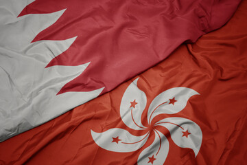 waving colorful flag of hong kong and national flag of bahrain.