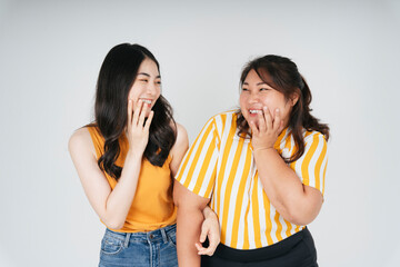 Cheerful happy two asian woman smile at each other.