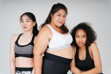 Fototapeta na wymiar Three diverse women with asian and african in sport bra outfit over white background.
