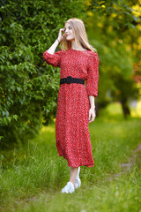 Girl in dress walking in the park and have a rest
