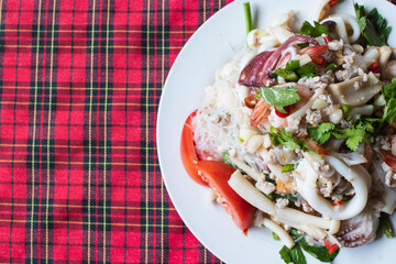 Thai street food is called seafood glass noodle salad (yum woon sen).