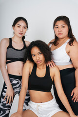 Three diverse women with asian and african in sport bra outfit on white background.