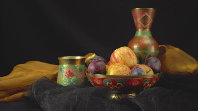 Still life with plums and apples on a dark background