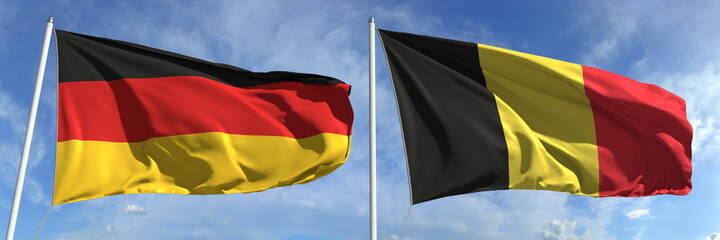 Waving flags of Germany and Belgium on flagpoles, 3d rendering