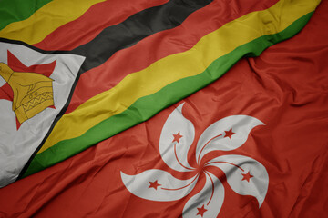 waving colorful flag of hong kong and national flag of zimbabwe.
