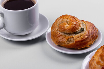 a cup of espresso and cinnamon roll