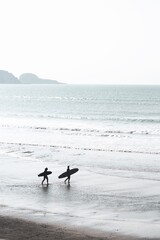 Surfing Lifestyle at the beach with two longboard girls and the ocean behind them