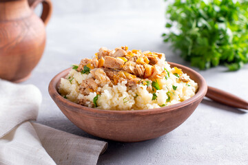 Couscous with meat in a bowl on a light table. Tasty dinner