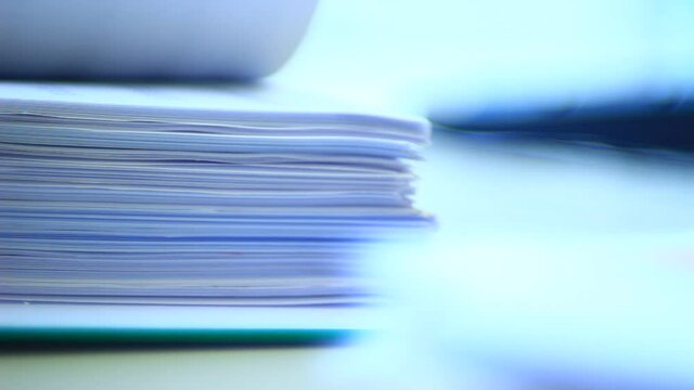 Close up of papers, stack of papers in the office. Slide the papers like a book.