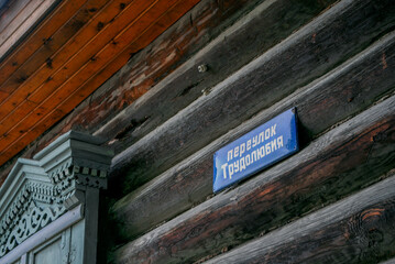 Street sign on wooden wall: Alleyway of Industriousness	(Pereulok Trudolyubiya)