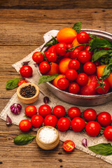 Assorted ripe multicolored tomatoes. Young garlic, fresh basil leaves, salt, spices