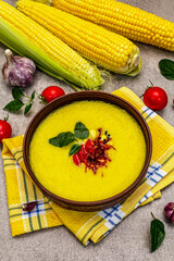 Corn cream soup with fresh vegetables, herbs and spices