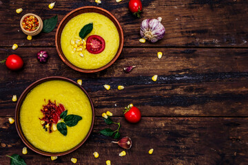 Fototapeta na wymiar Corn cream soup with fresh vegetables, herbs and spices