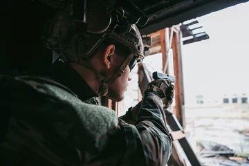 Tuinposter Soldier in combat. Urban combat training, soldier entering abandoned building. Anti terrorist operation battlefield training. © romankosolapov