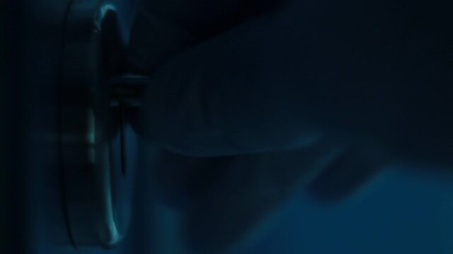 Fingers manipulate with key in a key lock. Close up, macro.