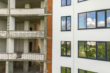 Many windows on new apartment building facade under construction.