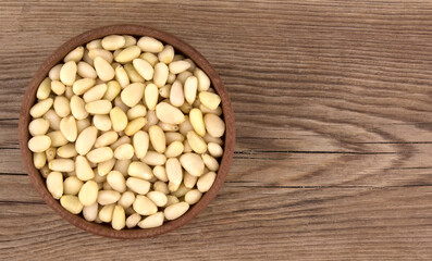Bowl with pine nuts on a wooden table