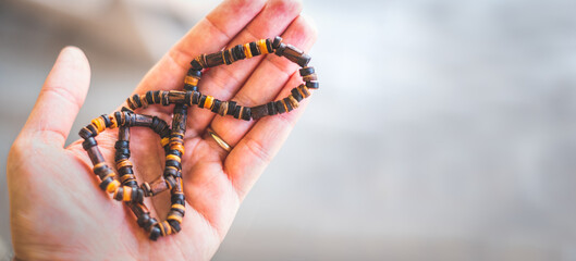 man hand hold necklace traditional wood horizontal background