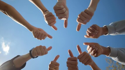 Bottom view of young people standing in a circle and showing thumbs up