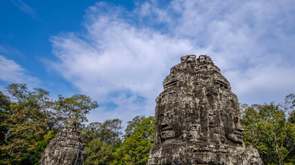 Fototapeta na wymiar Stone-carved faces in Angkor Thom complex during Khmer empire, Siem Reap, Cambodia. 