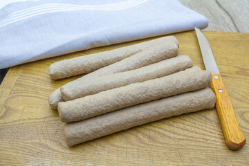 tas de fricadelles crues sur une planche à découper