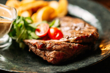Grilled beef with pepper sauce and potato wedges