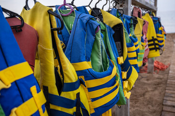 Row of life jackets, on a beach, ready for rent