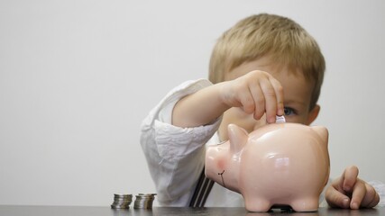 Economical child put money in piggy bank, treasure saving