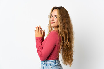 Young blonde woman isolated on blue background scheming something
