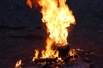 Pot burning in a fire on logs
