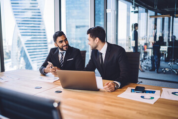 Fototapeta premium Smiling colleagues discussing strategy in office