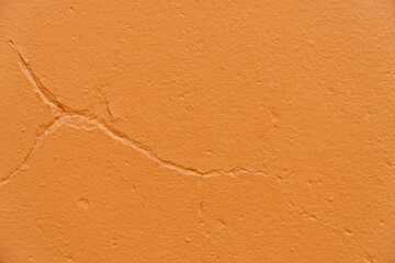 Abstract cracked blank orange cement concrete texture wall for background and wallpaper with copy space.