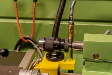 Close up of a spindle chuck and measurement scale  on a metal lathe machine
