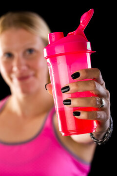 Woman holding pink bottle with energy drink