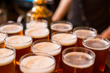 Glasses of light beer on a pub background.