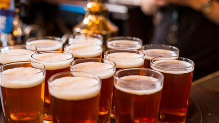 Glasses of light beer on a pub background.