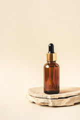 One brown bottle of cosmetics on a natural beige background. Stone podium. Front view.