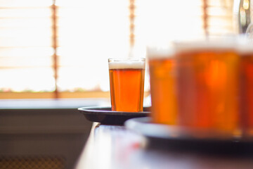 Glasses of light beer on a pub background.