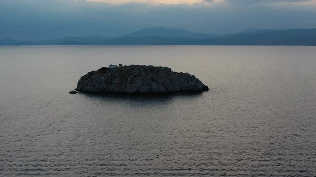 A small island in front of Vlychos Plakes Beach in Hydra Island, Greece