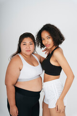 Diverse women with chubby asian and african woman in sportbra over white background.