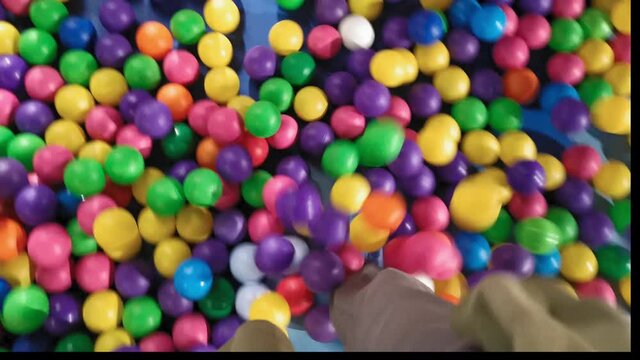 Man walks on plastic colored balls. Pool with multi-colored balls. . High quality 4k footage. HUAWEI MATE 20 X.