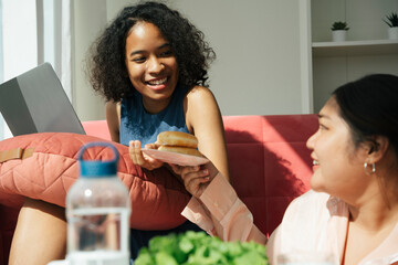 African and asian women living together at home.