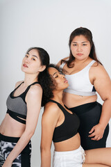 Fototapeta na wymiar Three diverse women with asian and african in sport bra outfit on white background.