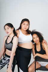 Three diverse women with asian and african in sport bra outfit on white background.