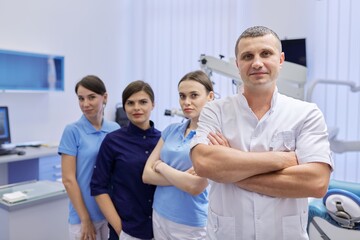 Portrait of male doctor dentist and female interns in the dental office