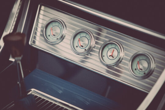 Tachometer, clock and various gauges on a vintage car's dashboard
