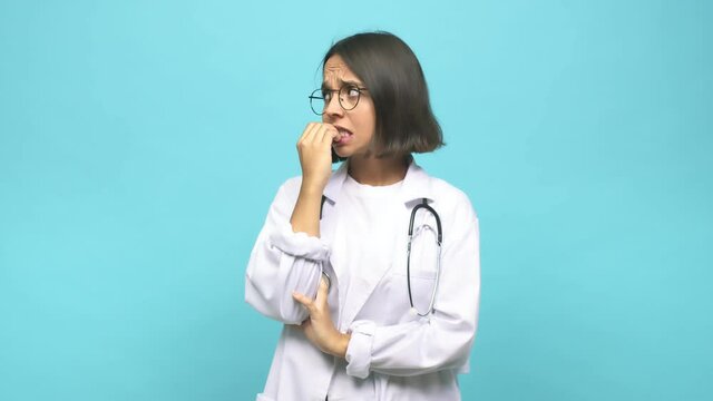 Young doctor indian woman biting fingernails, nervous and very anxious